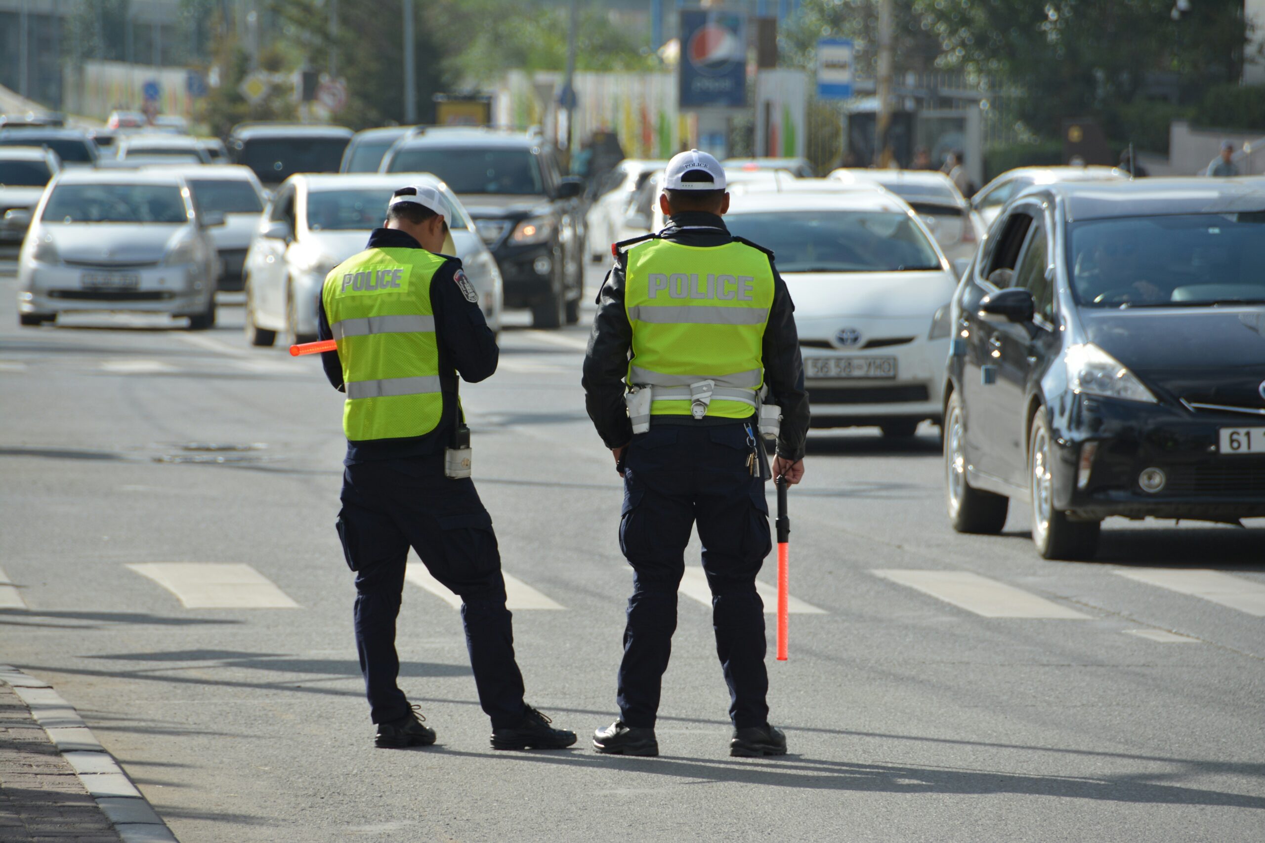 two police officers standing on the side of a road